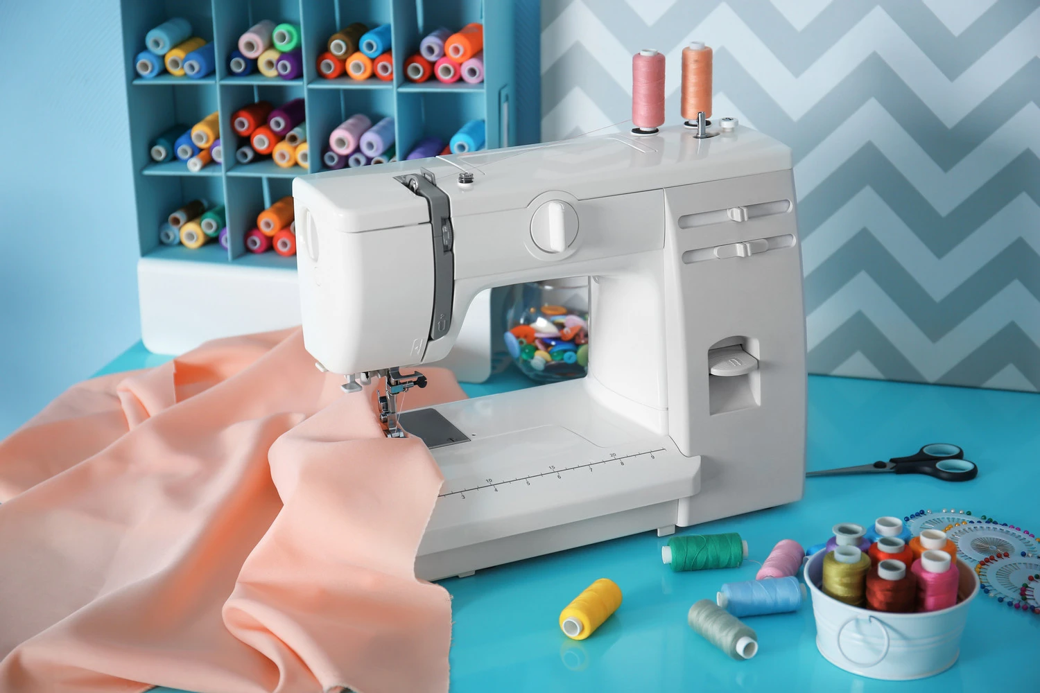 white sewing machine on blue table - Top Sewing Machines for Quilting Beginners