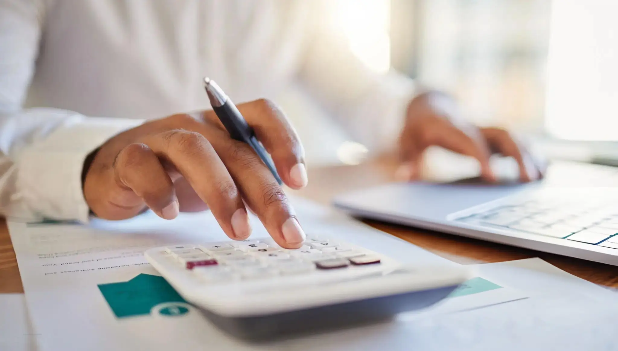 A businessman using a calculator to determine project costs for a quilting machine budget.