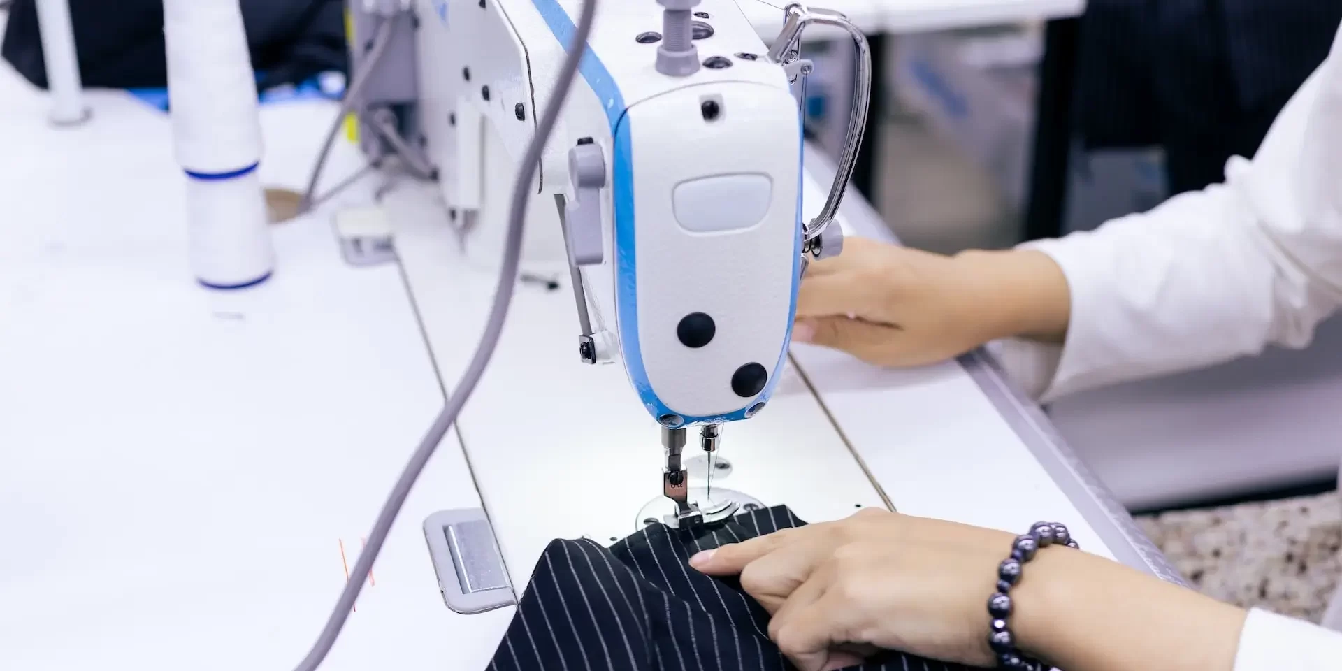 what is your skill level in quilting - A person skillfully operates a sewing machine for quilting, creating intricate stitches on fabric.