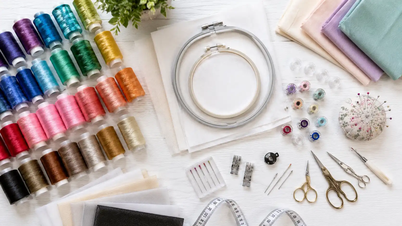 Essential embroidery supplies including thread stabilizers needles hoops and scissors